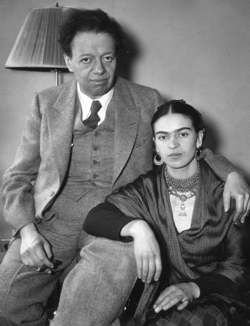 Black and white photograph of Diego Rivera seated beside Frida Kahlo